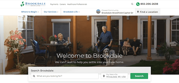 People sitting outside a senior living facility on a covered patio, with the text "Welcome to Brookdale" and a search bar below. Discover why our community is highlighted among the best assisted living websites for providing exceptional care and comfort.