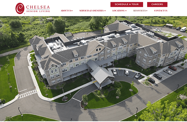 Aerial view of a large assisted living facility surrounded by greenery, with pathways and parking areas perfectly designed for residents seeking tranquility.